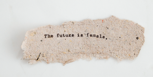 The future is female written on a piece of unevenly cut cardboard